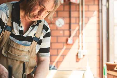 Person bearbeitet Holz